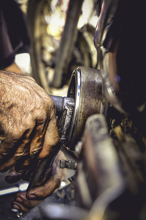 Mechanic removing magnetic wheels on motorcycle engine